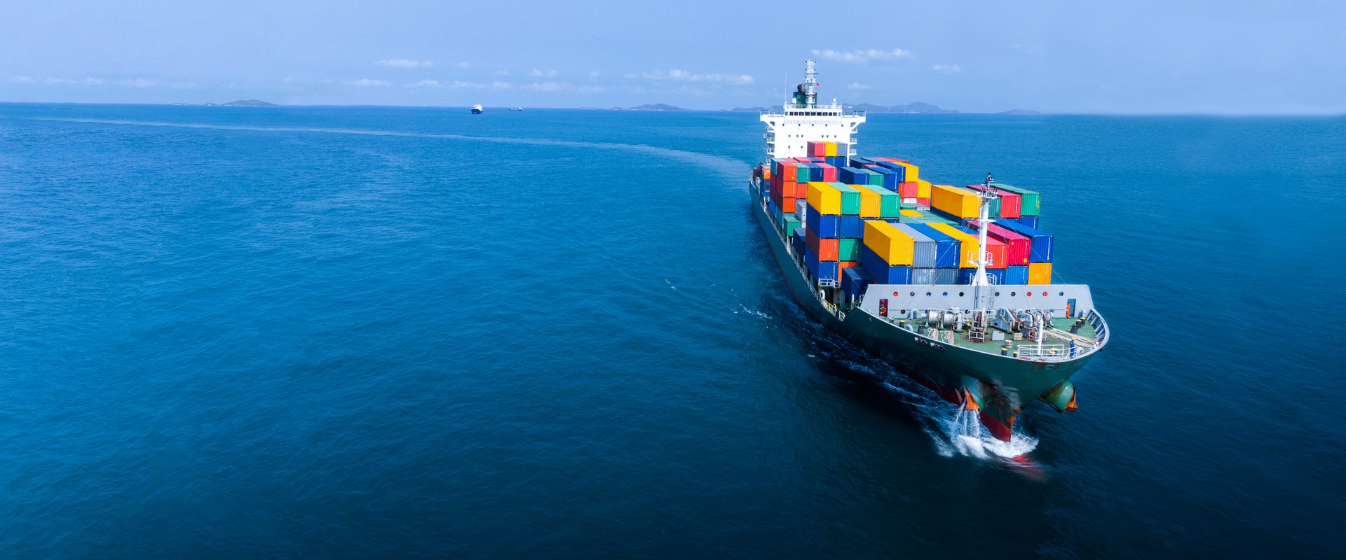 Aerial view of a fully loaded container ship crossing open ocean